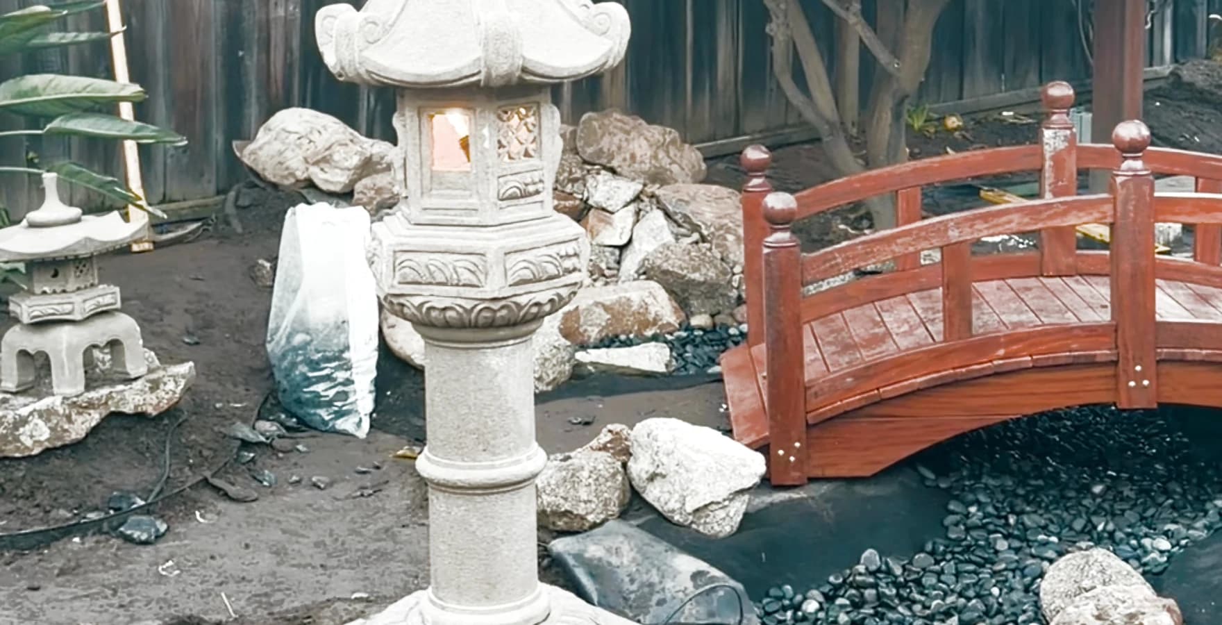 The timber bridge and stone lanterns in place during the final stages of garden installation