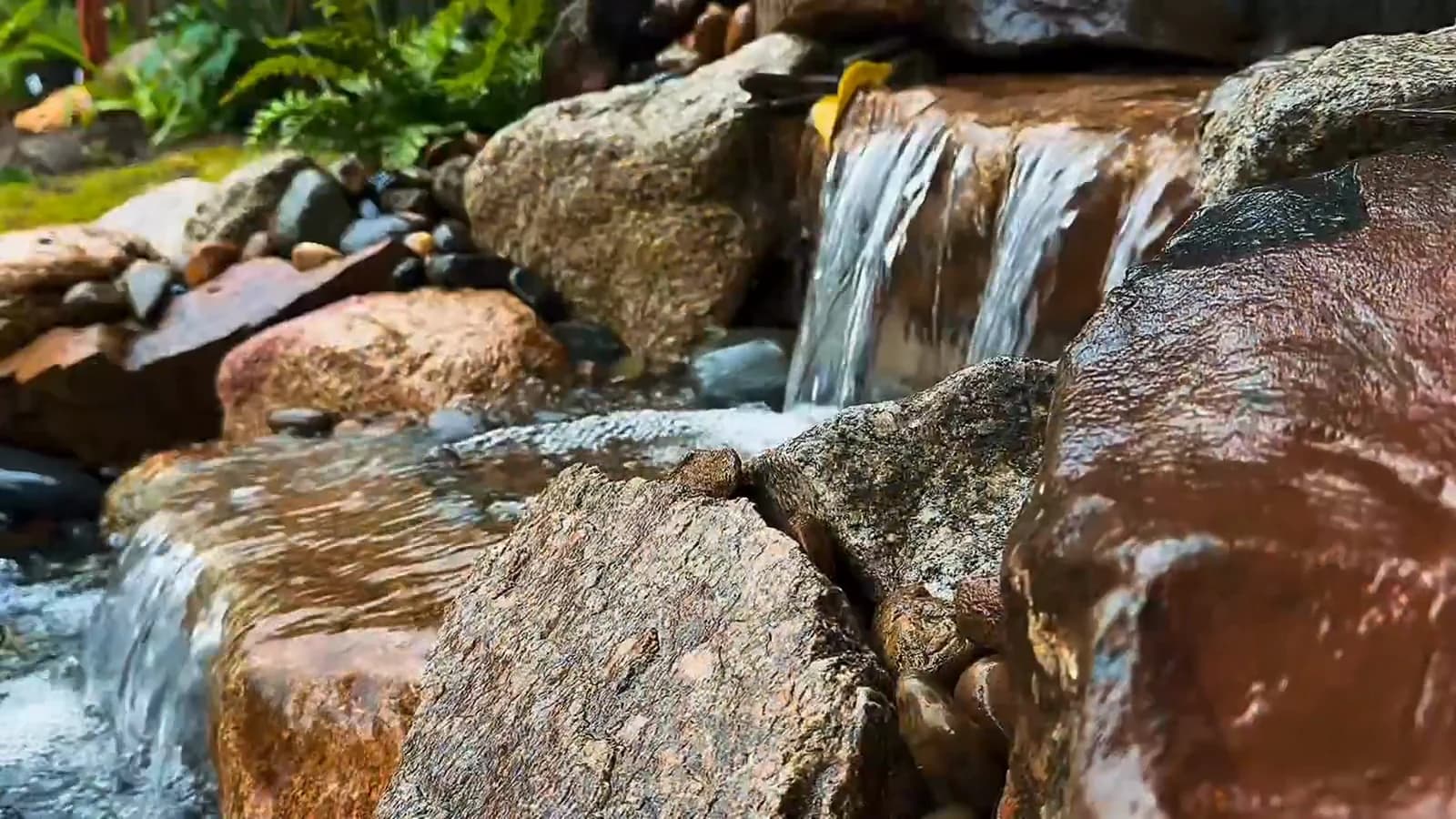 Water flowing over natural stone in the garden channel