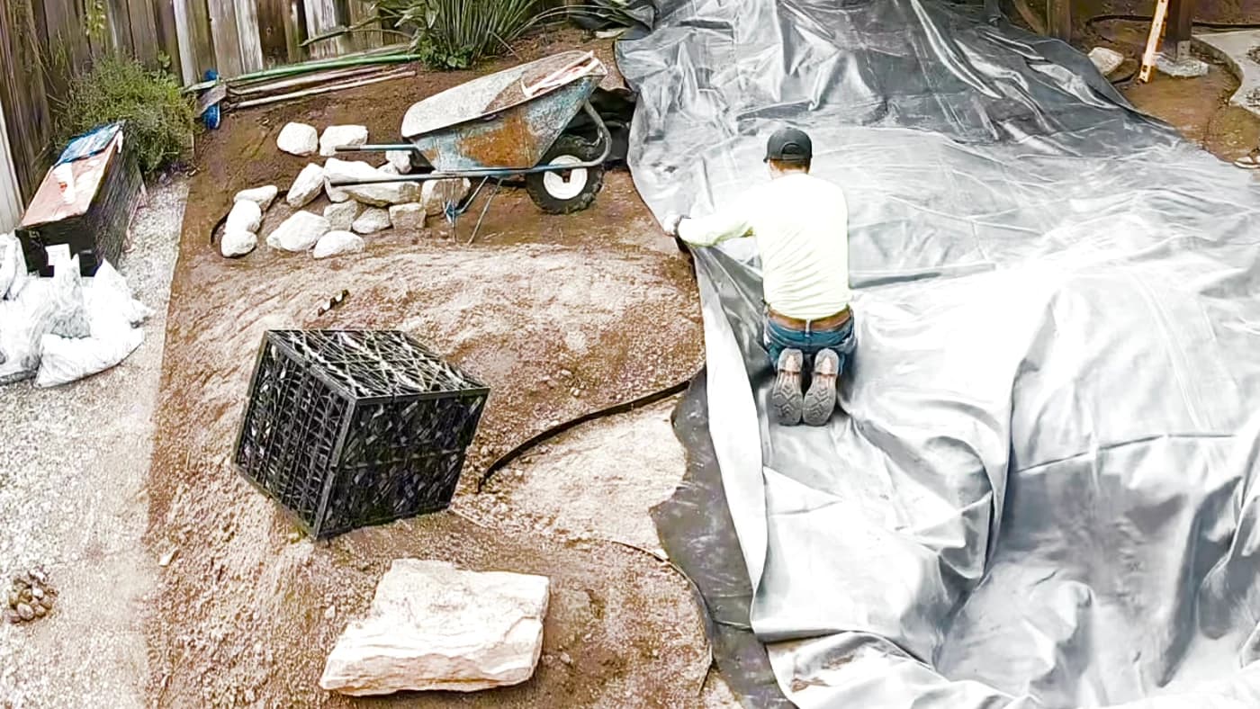 Protective fabric and lining laid across the prepared water feature excavation
